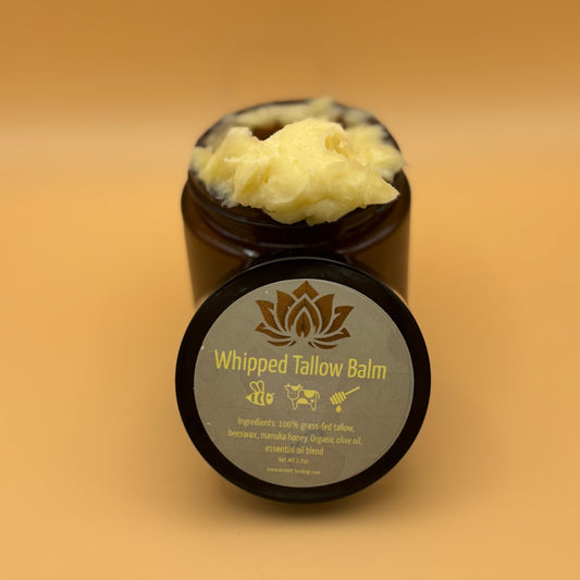 Jar of whipped tallow balm on a beige background